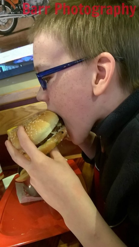 Zeb eating Red Robin burger with logo